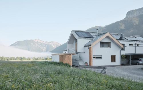 a white house with mountains in the background at Urban Alpine Penthouse with Lake View in Maurach