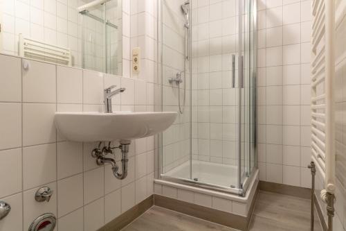 une salle de bain avec un lavabo et une douche dans l'établissement Neubau-Villa-Strandidyll-Typ-4-Apartment-1-2, à Binz