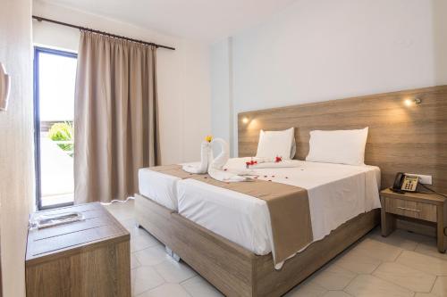a bedroom with a large bed and a large window at Tivoli Hotel in Faliraki