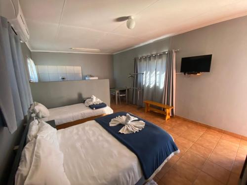 a hotel room with two beds and a flat screen tv at Hoon's Selfcatering in Karasburg