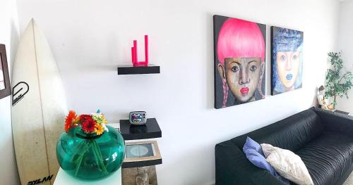 a living room with a couch and a vase on a table at Arthouse Surf Ericeira in Ericeira