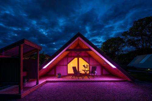 a lit up house with a table and chairs at Killarney Glamping at the Grove, Suites and Lodges in Killarney