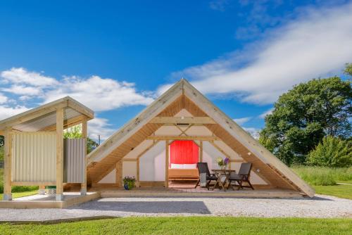 a tent with a table and chairs in a field at Killarney Glamping at the Grove, Suites and Lodges in Killarney