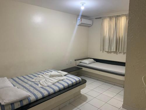- une petite chambre avec un lit et une fenêtre dans l'établissement Hotel Piramide St. Antonio de Jesus, à Santo Antônio de Jesus