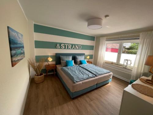 a bedroom with a bed and a striped wall at Lüttje Najade in Borkum