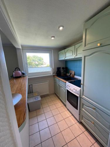 a kitchen with a white refrigerator and a window at Lüttje Najade in Borkum