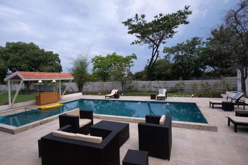 ナーシクにあるStayVista's Villaggio - Orchard Oasis with Pool, Expansive Lawn, Patio & Indoor Activitiesのスイミングプール(椅子付)、ガゼボ