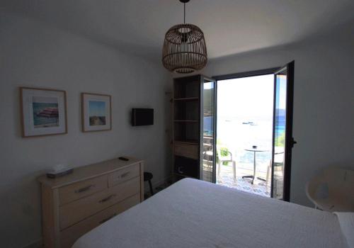 a bedroom with a bed and a view of the ocean at HOTEL CAMPOMORO in Campomoro