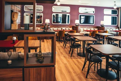 a restaurant with tables and chairs and a mirror at ibis Styles Wałbrzych in Wałbrzych