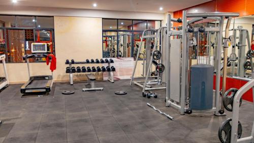 a gym with several treadmills and machines at M Hotel Kigali in Kigali