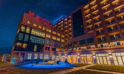 a hotel with two tall buildings at night at M Hotel Kigali in Kigali