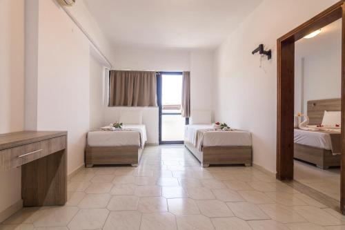 ファリラキにあるTivoli Hotelの病室にはベッド2台と鏡が備わります。