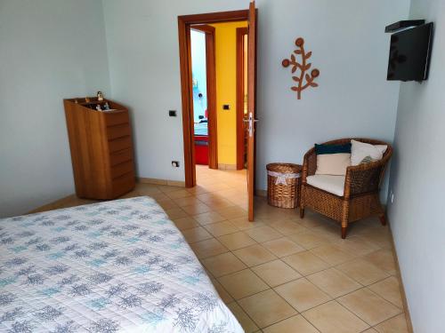 a bedroom with a bed and a television and a chair at Visitponza - Vesta in Ponza