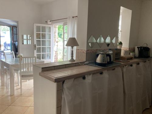a kitchen with a counter top and a dining room at Gîte Encore Un Soir in Hyères