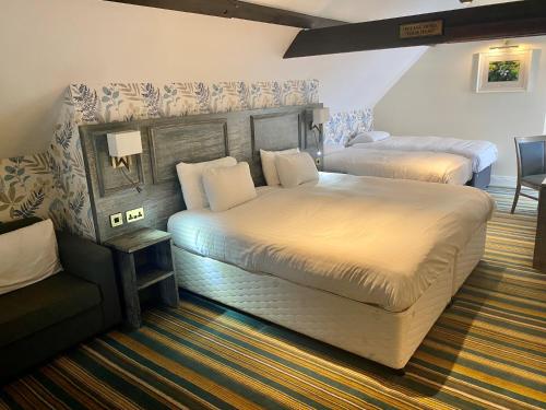 um quarto de hotel com duas camas e um sofá em The Hippodrome Wetherspoon em March