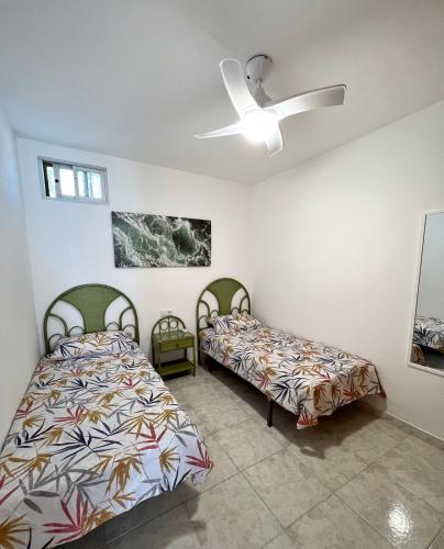 a bedroom with two beds and a ceiling fan at Donkey house in La Cala de Mijas