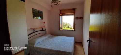 a small bedroom with a bed and a window at Trilocale a Scalea in Scalea