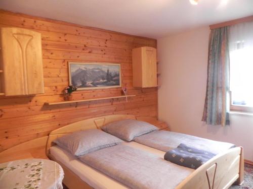 a bedroom with two beds in a wooden wall at Ferienwohnung Oberrauter in Bad Gastein