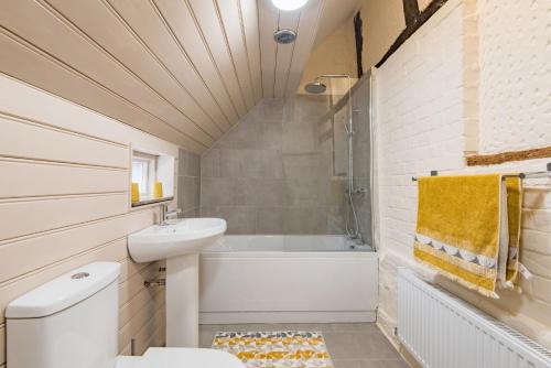 a bathroom with a toilet and a sink and a bath tub at Plum Pudding Cottage by Bloom Stays in Hernehill
