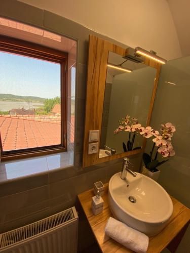 a bathroom with a sink and a mirror and a window at Centrum Vendégház in Tihany