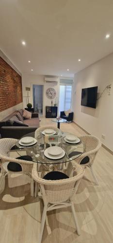 een woonkamer met een glazen tafel en stoelen bij Barcelona Apartamento en planta baja con Terraza in Hospitalet de Llobregat