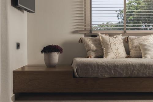 a bed with a vase on a wooden table next to a window at Panorama Inn in Lithakia