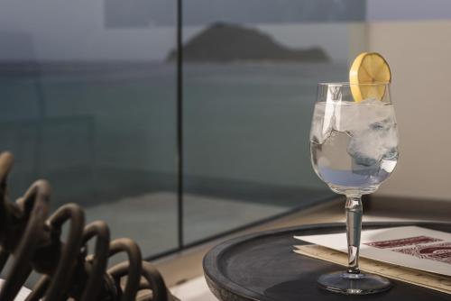 a glass of water with a lemon on a table at Panorama Inn in Lithakia