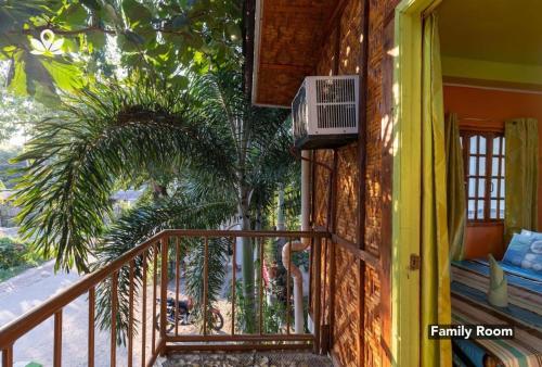 a balcony of a house with a palm tree at Hope Inn in Bolod