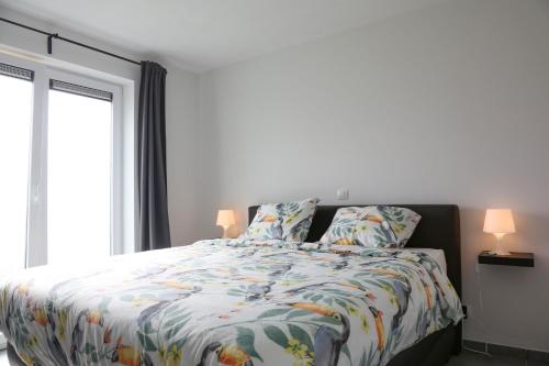 a bedroom with a bed with a colorful comforter at Villa Feliz in Nieuwpoort