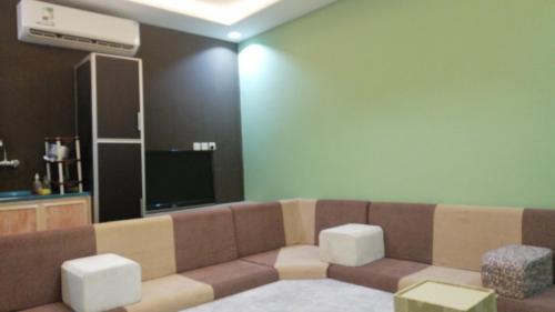 a living room with a couch and a flat screen tv at استراحة سكنية للإيجار اليومي والشهري in Az Zulfi