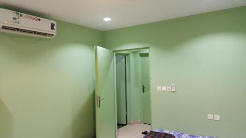 una camera con pareti verdi e porta per un bagno di استراحة سكنية للإيجار اليومي والشهري a Az Zulfi