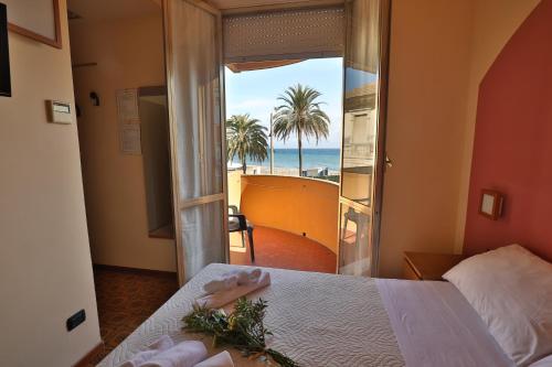 um quarto com uma cama e vista para o oceano em XXV APRILE Casa per Ferie em Albenga