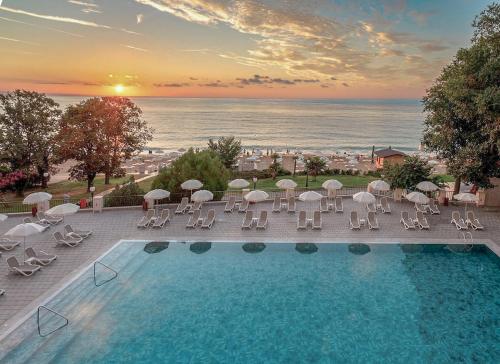 a view of a swimming pool with chairs and umbrellas at GRIFID Vistamar Hotel - 24 Hours Ultra All inclusive & Private Beach in Golden Sands