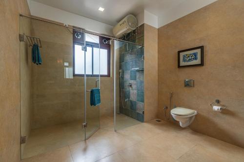 a bathroom with a shower and a toilet at Saffronstays Casa Del Palms, Alibaug - luxury pool villa with chic interiors, alfresco dining and island bar in Alibaug