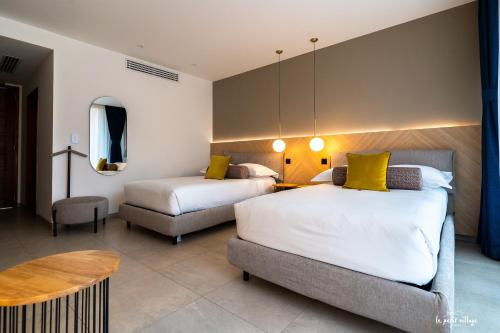 a hotel room with two beds and a table at Le Petit Village Boutique Hotel & Spa in Kampala