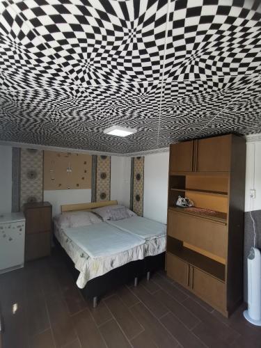 a bedroom with a bed and a black and white patterned ceiling at Edit Vendégház in Tiszaújváros