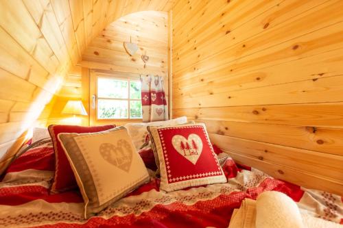 a bedroom with a bed in a log cabin at Cabane en bois avec bain nordique in Asnières-sur-Vègre