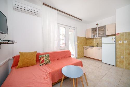 ein Wohnzimmer mit einem roten Sofa und einer Küche in der Unterkunft Apartments and Rooms Josipa in Vodice
