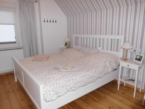 a white bedroom with a white bed and a table at Ferienwohnung Steckelsdorf in Rathenow