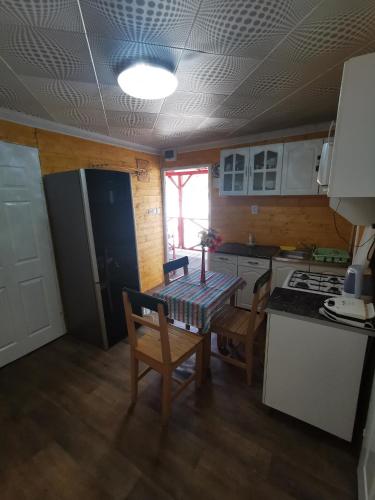 a kitchen with a table and chairs and a stove at Edit Vendégház in Tiszaújváros