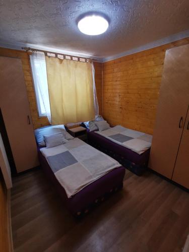 a room with two beds and a window in it at Edit Vendégház in Tiszaújváros