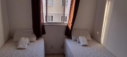 a room with two beds and a window at Cantinho dos Rehm in Fortaleza