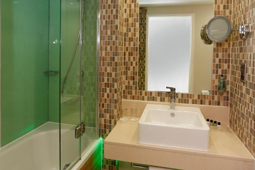 a bathroom with a sink and a glass shower at Holiday Inn Southend by IHG in Southend-on-Sea