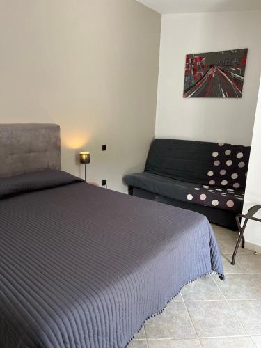 - une chambre avec un lit et un futon dans l'établissement Les Jardins De Santa Giulia - Charmante chambre dhte 2, à Porto-Vecchio