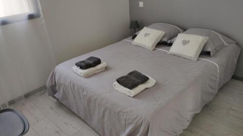 2 almohadas en una cama en una habitación en Jolie petite maison à 50 mètres de la plage en Cap d'Agde