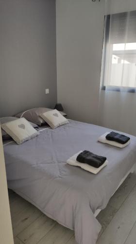 Una gran cama blanca con toallas encima. en Jolie petite maison à 50 mètres de la plage en Cap d'Agde