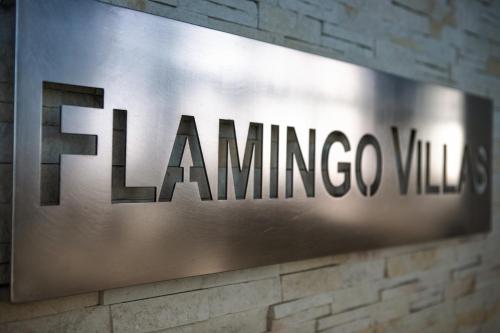 a sign for the lamning co logo on a brick wall at Flamingo Villas Boutique Hotel in Walvis Bay