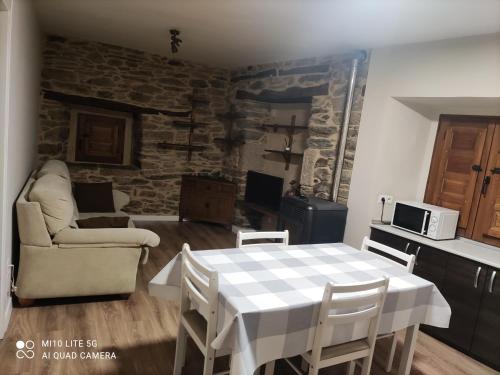 cocina y sala de estar con mesa y sillas en Casa marina, en Puebla de Sanabria