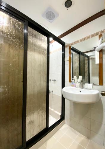a bathroom with a sink and a shower at TLT Condotl E-217 at Kiener Hills Condominium in Mactan