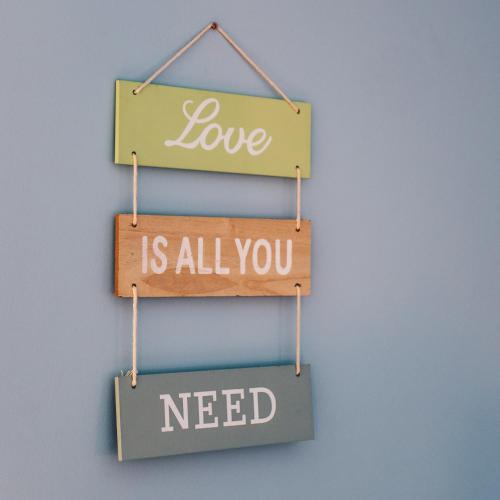 a sign that says love is all you need at Dom Uzdrowisko in Tolkmicko